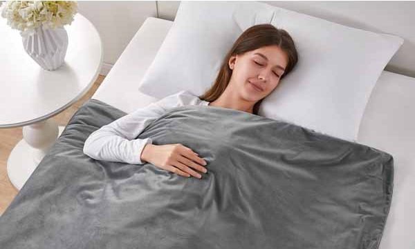 woman sleeping with grey aldi weighted blanket 