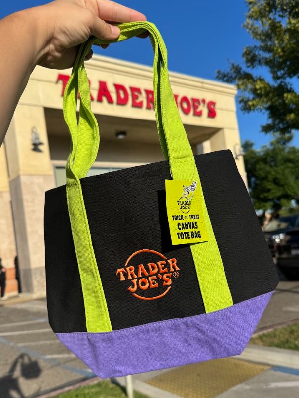 Returning black Halloween mini canvas tote with green handles, purple base, and orange embroidered logo